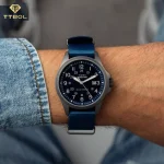 ساعت مچی مردانه تایمکس مدل TW2Y31700 روی مچ با صفحه سرمهای و بند پارچهای
